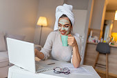 Girl is working from home, she has face mask and she is in the bath robe.