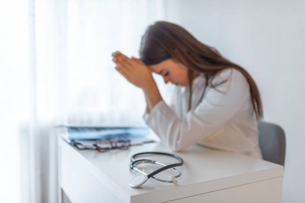 istock Stressed female doctor sat at his desk. 1161432577