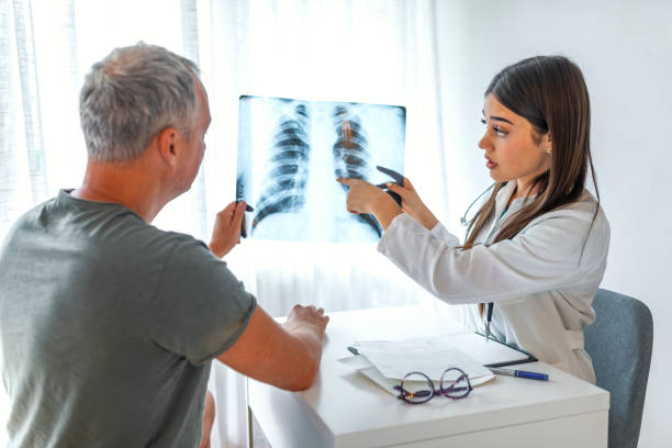 medico e paziente che guardano la radiografia del torace insieme. - human lung x ray image x ray human spine foto e immagini stock