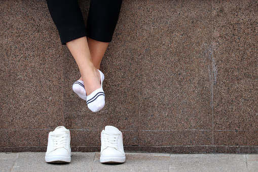 Female feet in white socks, girl sitting and relaxing after running