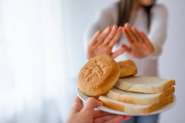 молодая женщина на безглютеновой диете говорит нет благодаря тост - dieting food rejection women стоковые фото и изображения