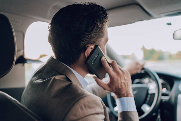 istock Businessman Talking on the Phone while Driving a Car 1161437394