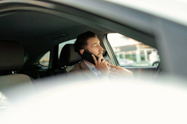 istock Businessman Talking on the Phone while Driving a Car 1161437653