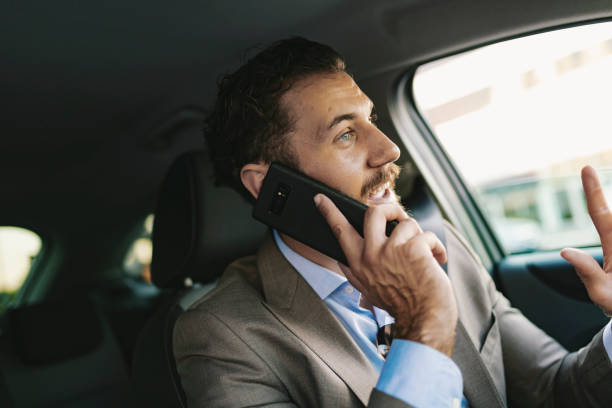 istock Businessman Talking on the Phone while Driving a Car 1161437912
