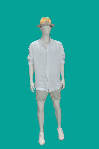 Full-length male mannequin dressed in summer casual clothes, isolated on green background. No brand names or copyright objects.
