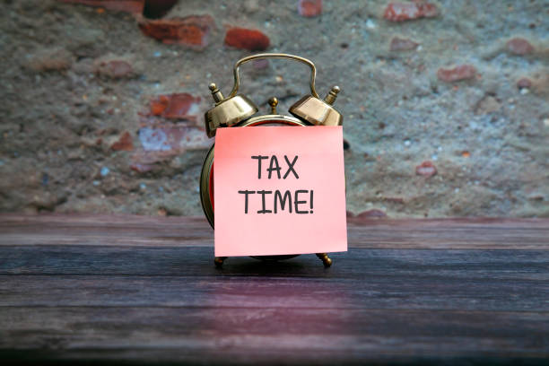 istock Tax time sticky note on antique clock 1161438774