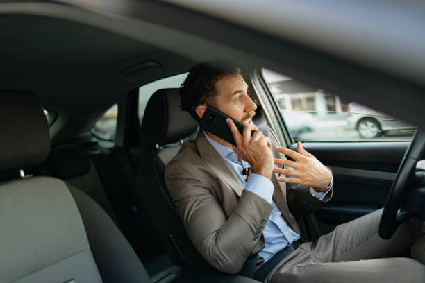 istock Businessman Talking on the Phone while Driving a Car 1161438788