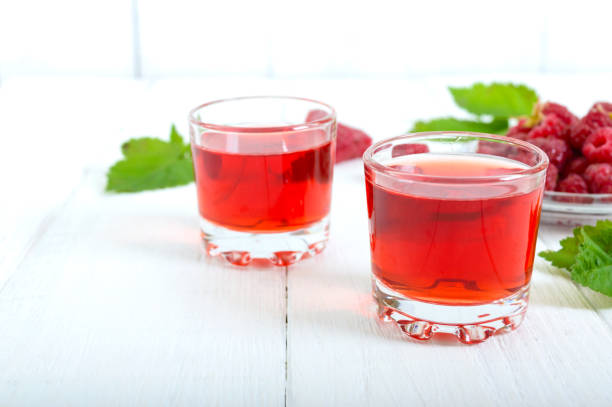 istock Raspberry liqueur in glass and fresh berries on a white background. Alcoholic flavored drink. 1161440703