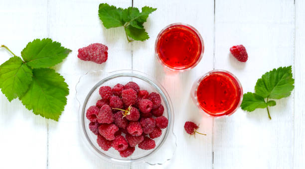 istock Raspberry liqueur in glass and fresh berries on a white background. Alcoholic flavored drink. The top view, flat lay 1161440710