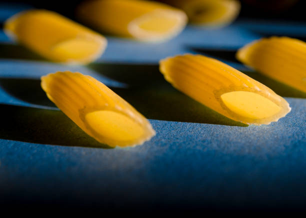 Penne Pasta is a sharp shadow against a colored background