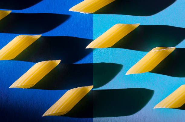 Penne Pasta is a sharp shadow against a colored background