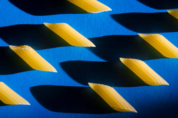 Penne Pasta is a sharp shadow against a colored background