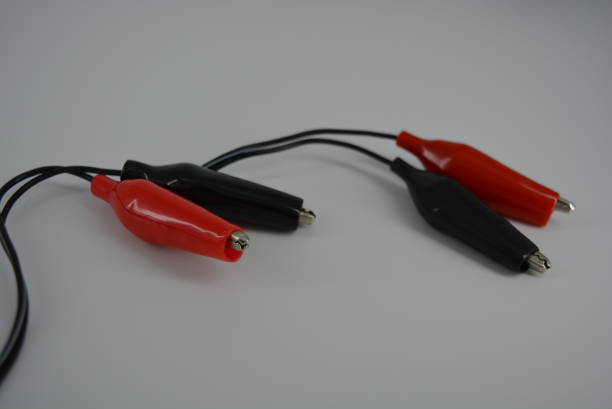 istock Electrical wire with red and black connectors for connecting to a power source, plus and minus from the mains, battery. Metal crocodiles in a tight rubber shell for a safe and comfortable electrical connection. 1161446122