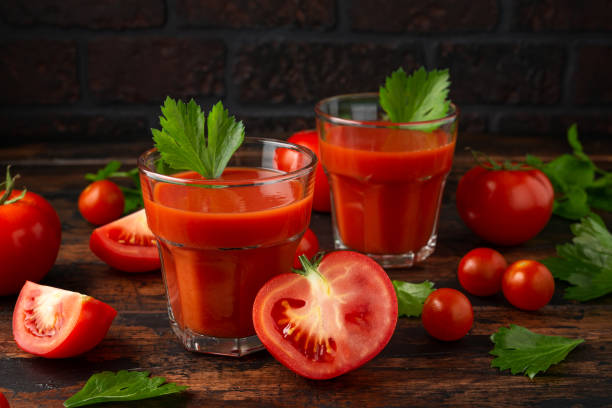 istock Tomato juice in glass with celery on rustic wooden table 1161446144