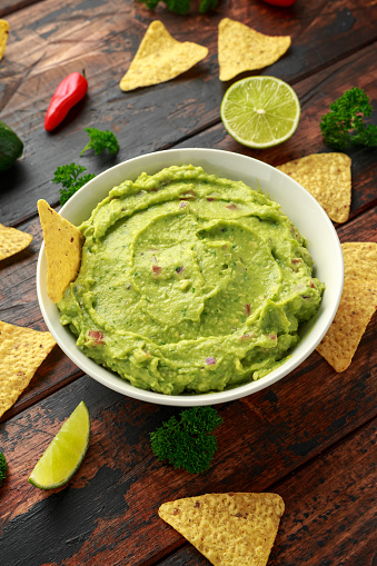 Bowl of fresh Guacamole with nachos chips and herbs. Healthy Vegan, Vegetables food