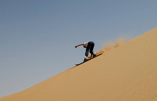 sandboarden in der sahara - snowboard extreme sports speed motion stock-fotos und bilder