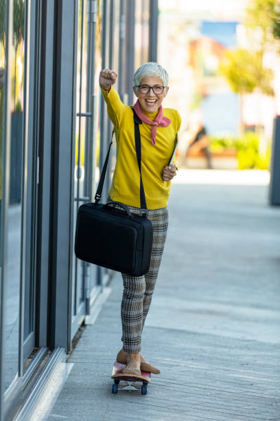 istock Senior Businesswoman Standing On Skateboard 1161448068