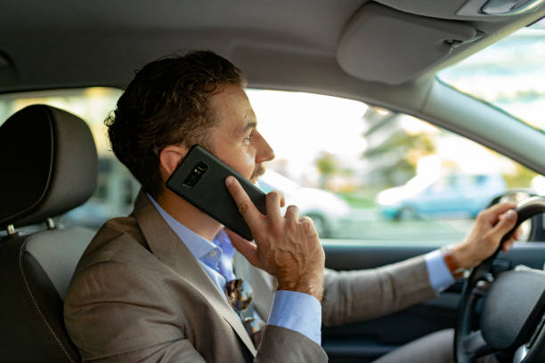 istock Businessman Talking on the Phone while Driving a Car 1161449447