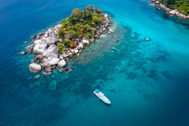 istock Small tourist boat next to small green island 1161453817