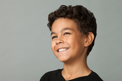 Closeup studio portrait of a 12 year old boy on gray background