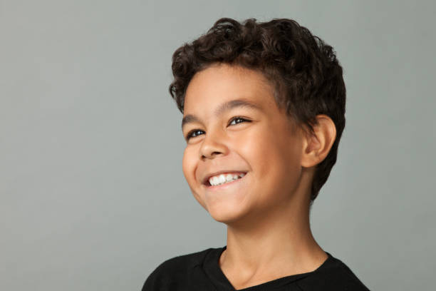 Closeup studio portrait of a 12 year old boy on gray background stock photo