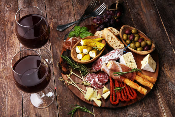 istock antipasto various appetizer. Cutting board with prosciutto, salami, cheese, bread and olives on dark wooden background 1161459748