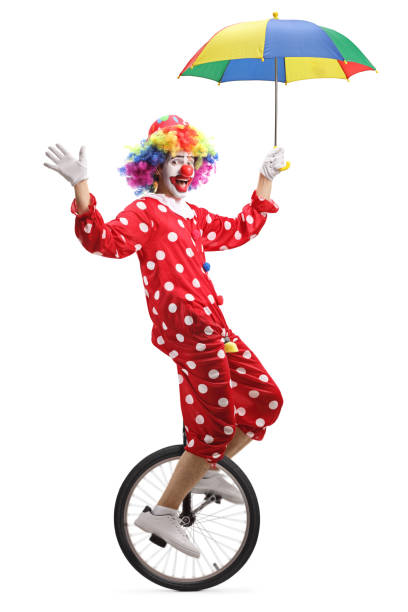 istock Clown riding a unicycle and holding an umbrella 1161459831