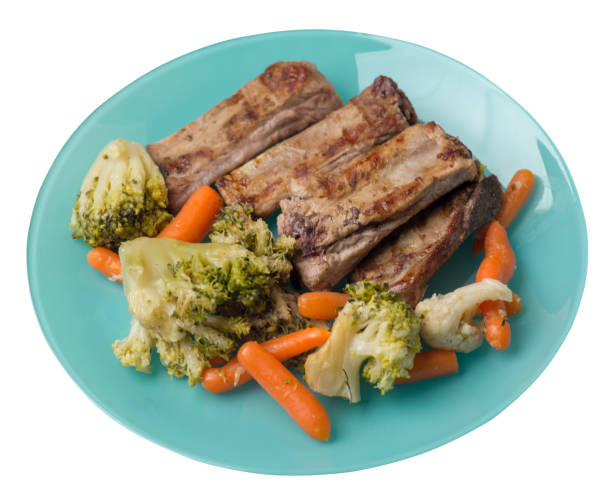 istock grilled pork ribs with broccoli cabbage, carrots and garlic on a plate. fried   ribs with vegetables on a white background. hearty rustic food top view 1161459908