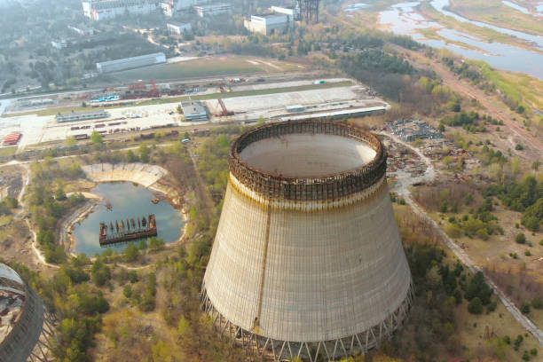 Drone flies over the cooling tower, top view Drone flies over the cooling tower near Chernobyl nuclear power plant., zoom out, close up, top view. Flying over the cooling tower near the Chernobyl nuclear power plant. Territory near Chernobyl NPP city zoom out stock pictures, royalty-free photos & images