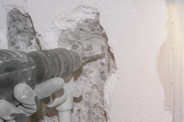 istock Hammer Drill in the hand in glove drills concrete wall. 1161466443