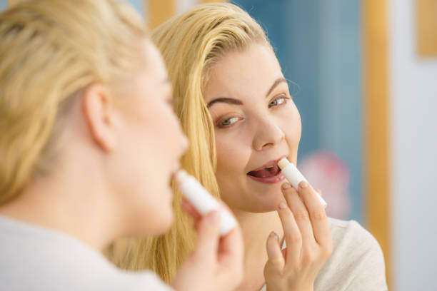 istock Woman in bathroom applying lip balm 1161469283
