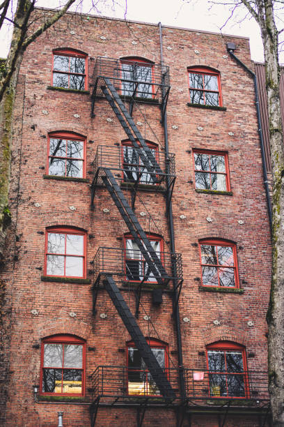 istock Old Red Brick Building with Black Metal Fire Escape Staircase 1161471226