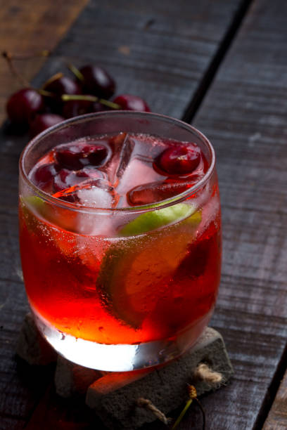 istock cherry and lime cocktail on a wooden floor with garnish 1161471415