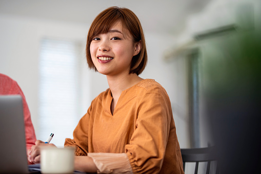 Newly married Japanese woman sitting down with her husband to do research and plan for future investments.