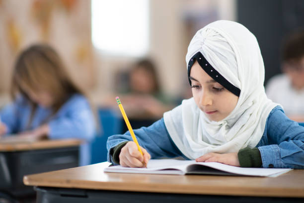 istock Muslim Girl Writing in her Notebook in Class 1161475952