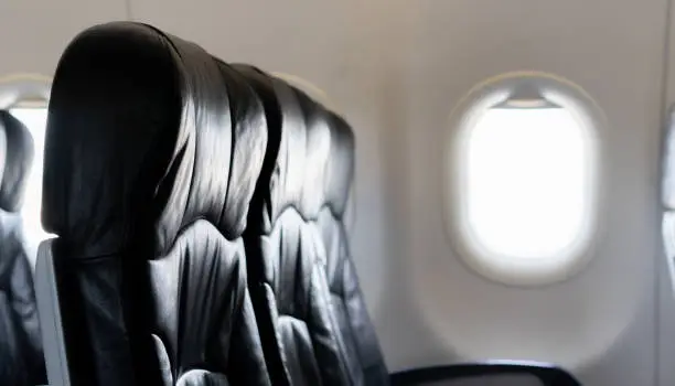 closeup black leather airplane at window seat background for business, traveling in holiday concept