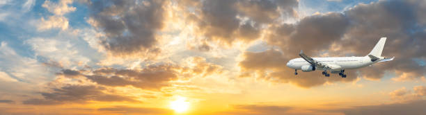 istock Airplane in the sky at sunrise 1161477577