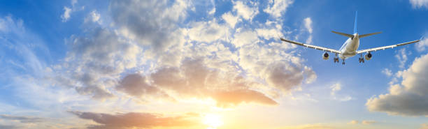 istock Airplane in the sky at sunrise 1161478120