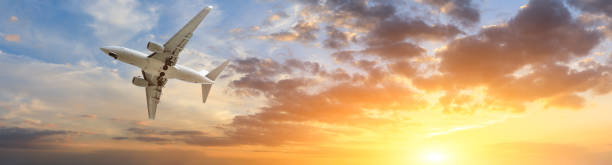 istock Airplane in the sky at sunrise 1161478143