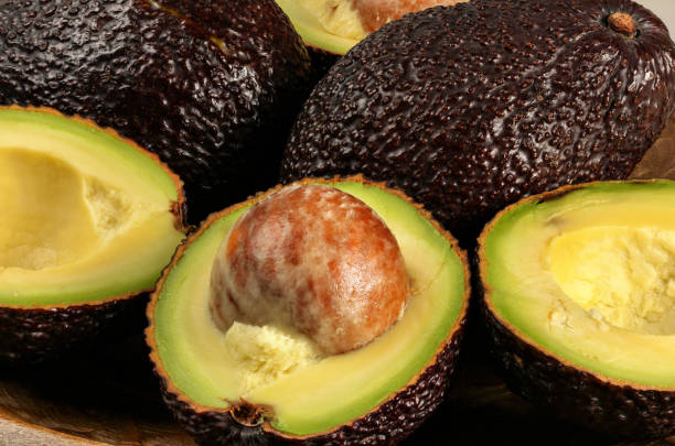 クローズアップ写真 - 熟した茶色のアボカドは、半分のビルス品種、フルーツシードの詳細を持っています - avocado brown 写真 ストックフォトと画像