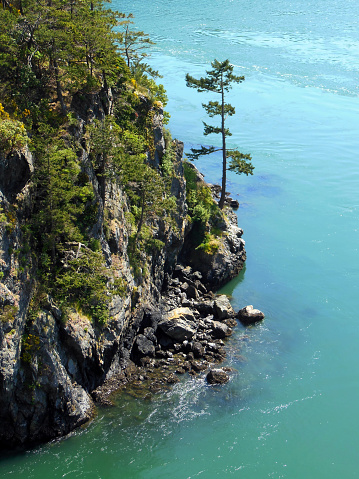 View from Deception Pass Bridge of the rocky cliffs at the edge of a swift moving current, Whidbey Island, Washington