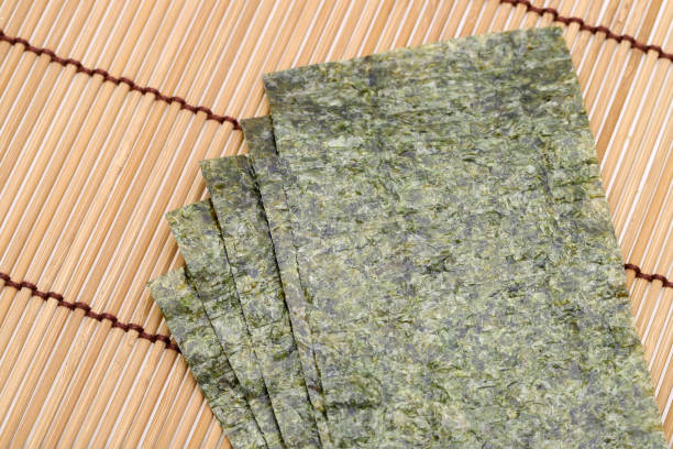 Japanese food, Nori dry seaweed sheets Japanese food, Nori dry seaweed sheets on bamboo mat nori edible seaweed sheet stock pictures, royalty-free photos & images