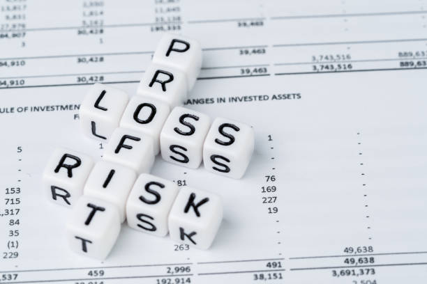 Risk, profit and loss in investment concept, small white cube block with alphabet building the crossword word mainly as Profit with the word Loss and Risk on financial investment reports stock photo