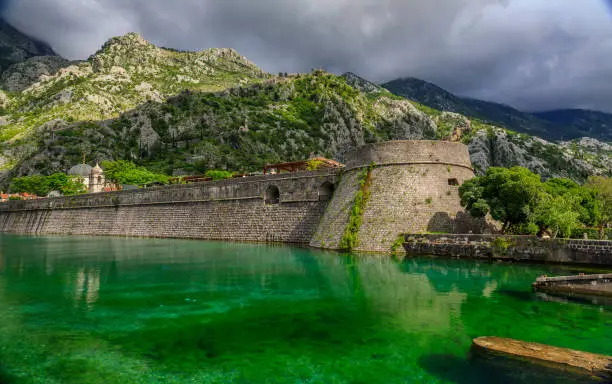 Photo of Emerald green waters of Kotor Bay or Boka Kotorska and the ancient wall of Kotor former Venetian fortress in Montenegro