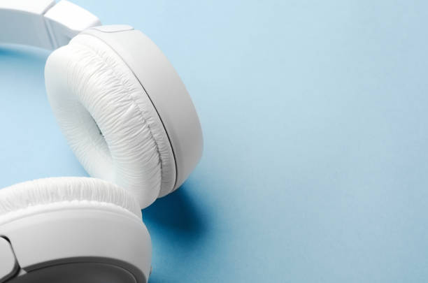 istock White overhead wireless bluetooth headphones on a blue background. Close-up, copy space. 1161509942