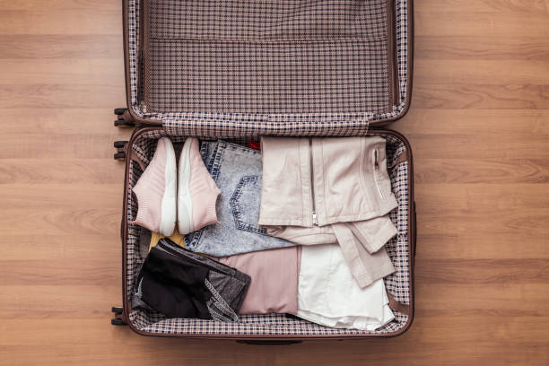 vista dall'alto di un bagaglio imballato o una valigia per il viaggio. - skirt women jeans white foto e immagini stock
