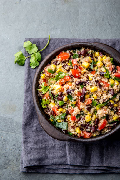 istock Mexican black bean corn quinoa salad in clay bowl top view, copy space 1161511292