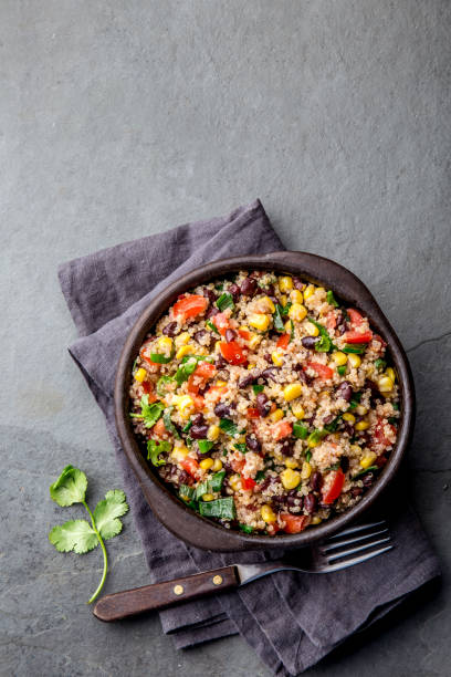 istock Mexican black bean corn quinoa salad in clay bowl top view, copy space 1161511302