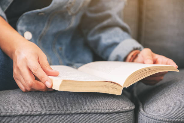 istock a woman sitting and reading a vintage novel book 1161511306