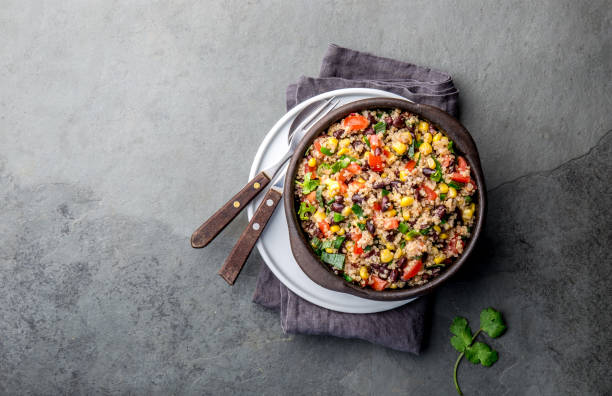 istock Mexican black bean corn quinoa salad in clay bowl top view, copy space 1161511307